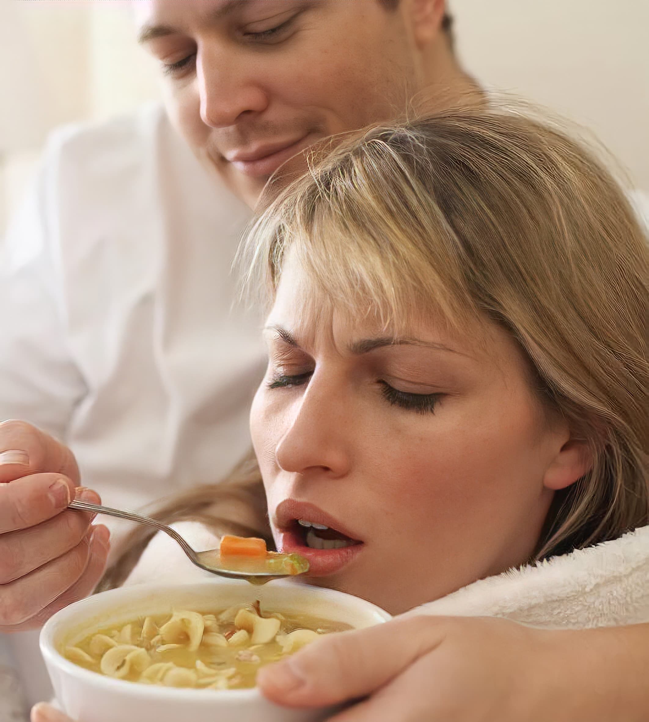 Man feeding girl soup